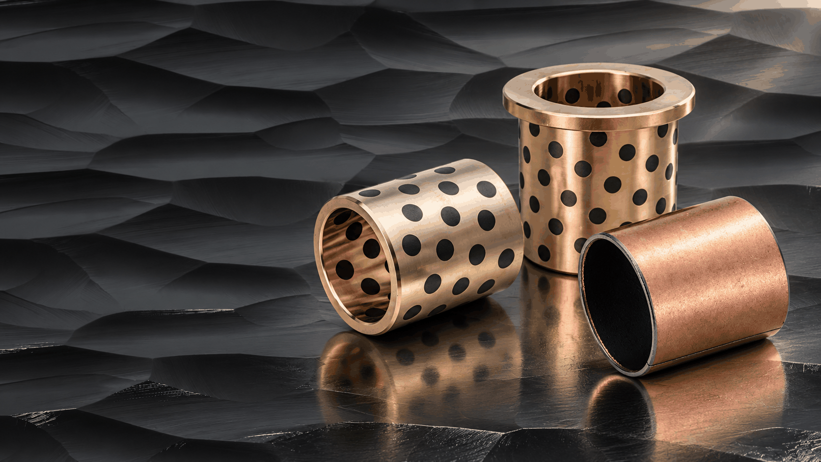 Graphite-plugged cylindrical and flanged bushings with a composite bushing